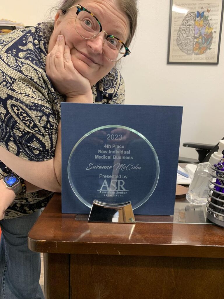 Suzie McColm with Washington State award for new individual health and medicare insurance, Medigap
